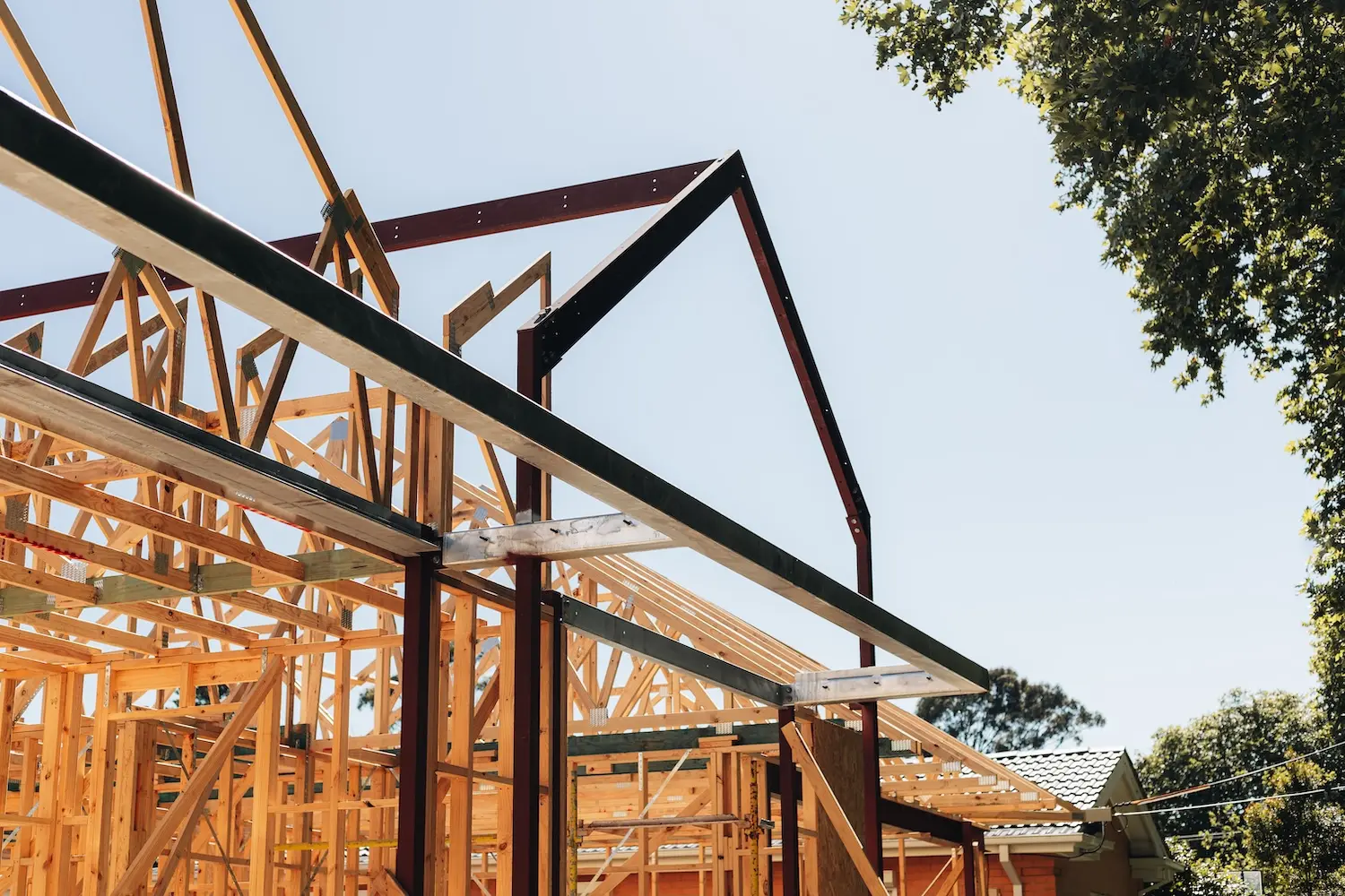 Timber and steel roof framing of a building under construction by NDK Constructions