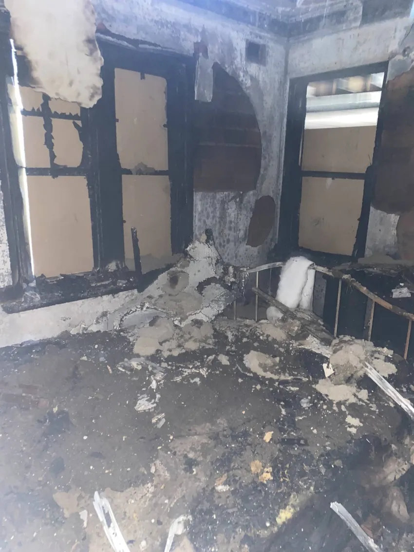 Bedroom after being burnt from a fire with everything severely damaged.